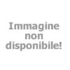 Bambino felice con secchiello, gioca sulla spiaggia soleggiata.